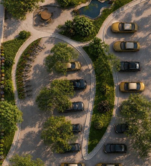 Aerial view of a parking lot with curved driving lanes, trees, and several parked cars.