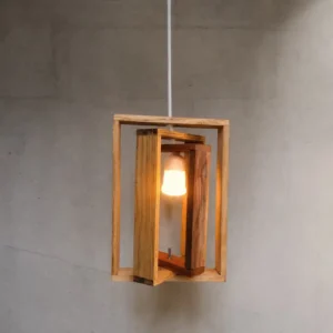 Wooden rectangular frame pendant light with an inner frame and glowing bulb, hanging against a gray wall in a minimalist space.