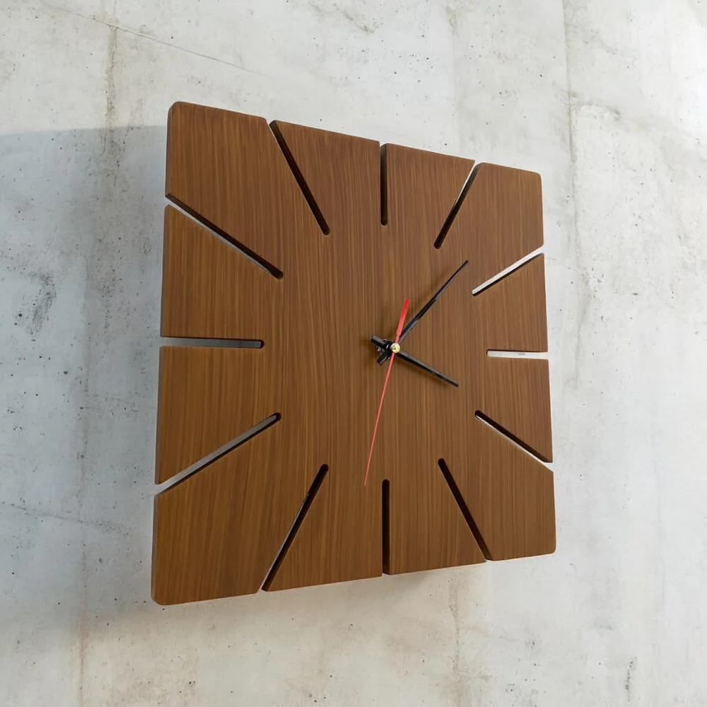 ebb07a39-e7e0-40f5-bc49-89442e3d450c - Artoza Crafts | Where Craft Becomes Style Wooden square wall clock with radial cut-out hour markers and red second hand on a light wall