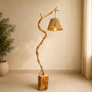 Curved wooden floor lamp with a wicker shade standing on a log base in a minimalist living space, plant to the left.
