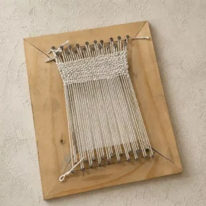 handmade DIY frame loom - Artoza Crafts | Where Craft Becomes Style Wooden wall loom with white warp threads and a small woven textile mounted on a rectangular wooden frame, as wall art.