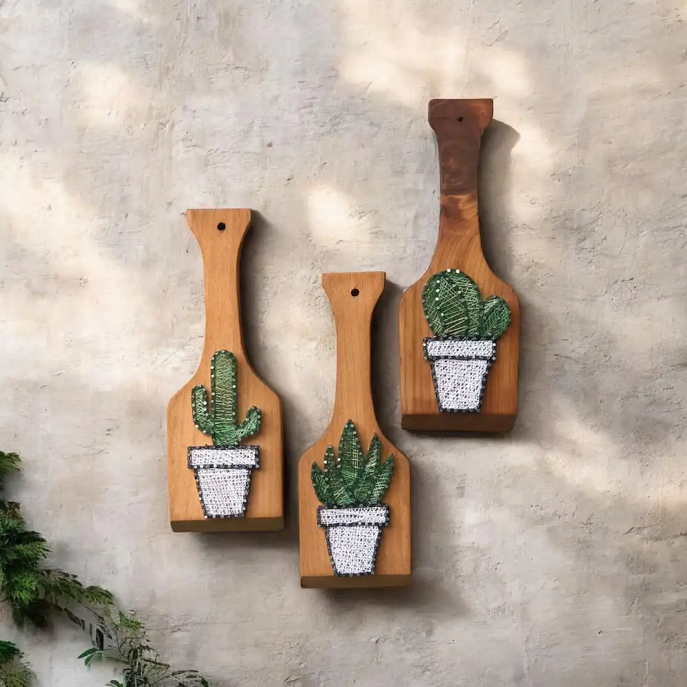 kitchen decor ideas - Artoza Crafts | Where Craft Becomes Style Three wooden cutting boards mounted on a gray wall, each with a crocheted cactus in a pot.|lm:2