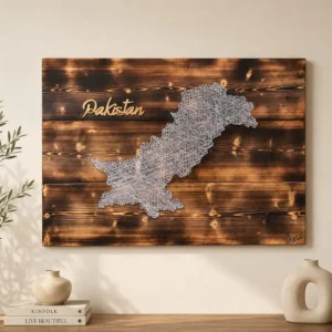 Wooden wall art showing a white lace-like map of Pakistan with the word Pakistan in gold script on a dark stained background.