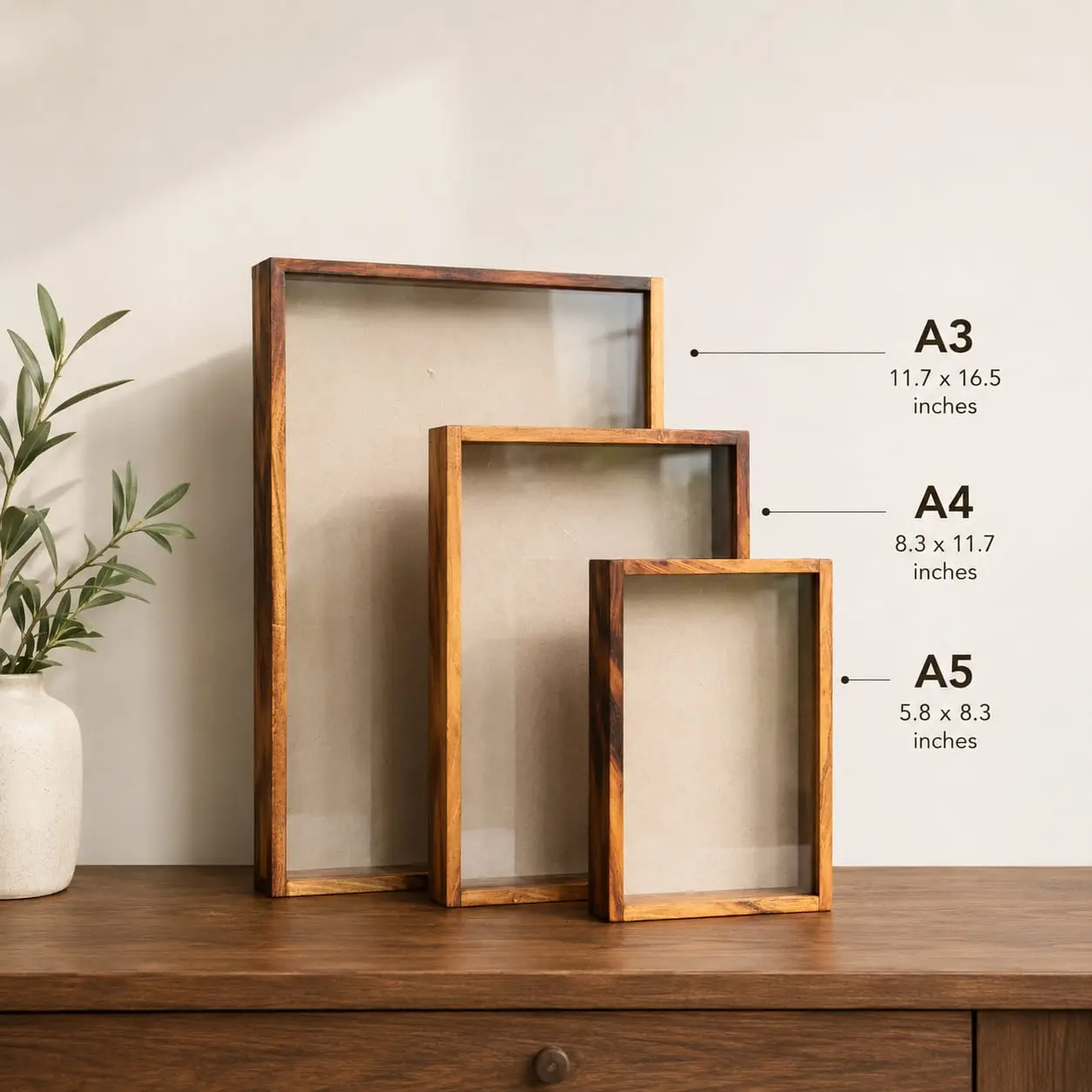 shadow box - Artoza Crafts | Where Craft Becomes Style Three wooden empty picture frames of sizes A3, A4, and A5 leaning on a wooden surface with a potted plant to the left; wall labels show dimensions A3, A4, A5 (inches).