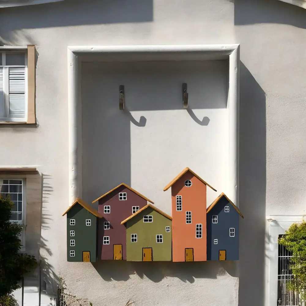 small wooden letter box - Artoza Crafts | Where Craft Becomes Style Row of colorful wooden houses attached to a light exterior wall, with two hooks above them.