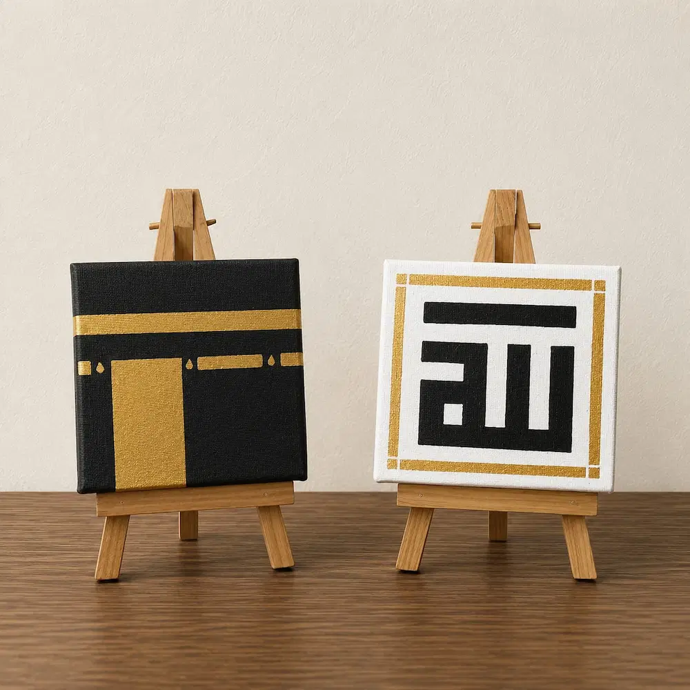 tabletop islamic painting - Artoza Crafts | Where Craft Becomes Style Two small canvases on wooden easels: left black with gold geometric shapes, right white with a black stylized 'ai' inside a gold-bordered frame.