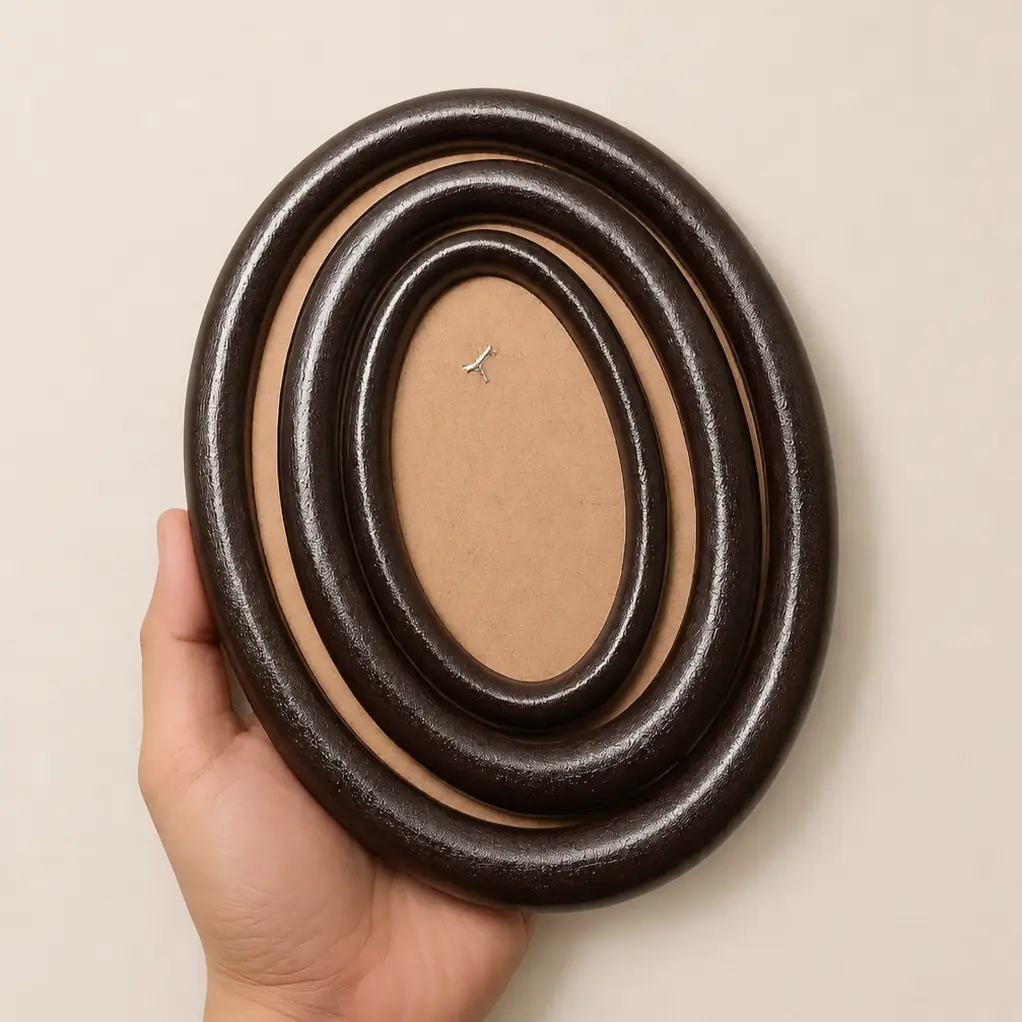 wooden circle frames - Artoza Crafts | Where Craft Becomes Style Hand holding three nested black circular rings forming an oval spiral on a light background.