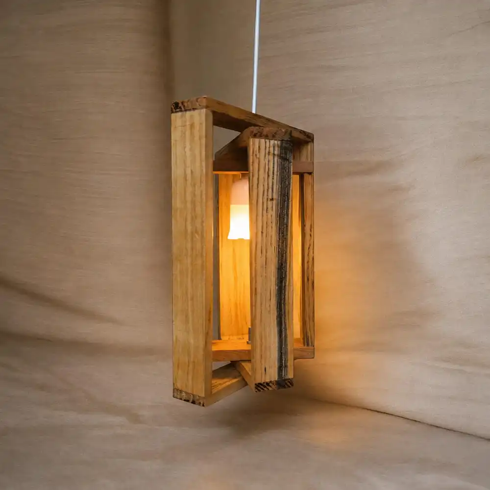 wooden hanging light - Artoza Crafts | Where Craft Becomes Style Wooden hanging lantern-style light fixture emitting a warm glow against a neutral background, decorative lamp.