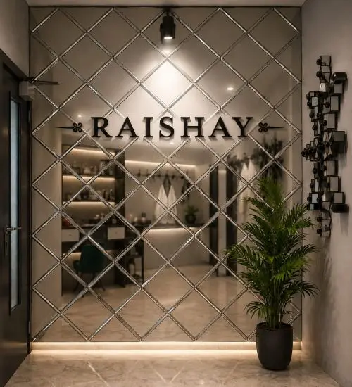 Shopfront glass door with a diamond lattice and the 'RAISHAY' logo; warm interior lighting, shelves visible inside, and a potted plant on the right.